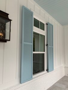 Custom louvered shutters on a modern farmhouse exterior in a deep matte finish.